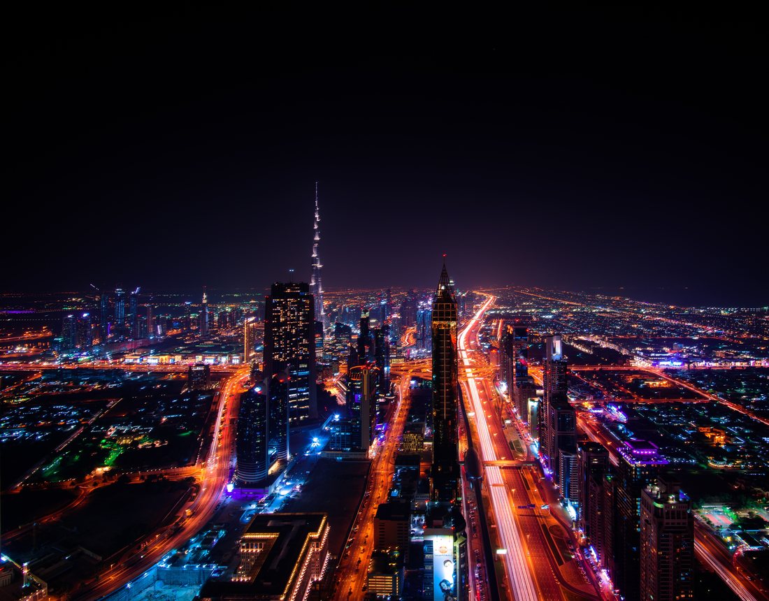 Dubai at night seen from above, traffic light trails along Sheikh Zayed Road